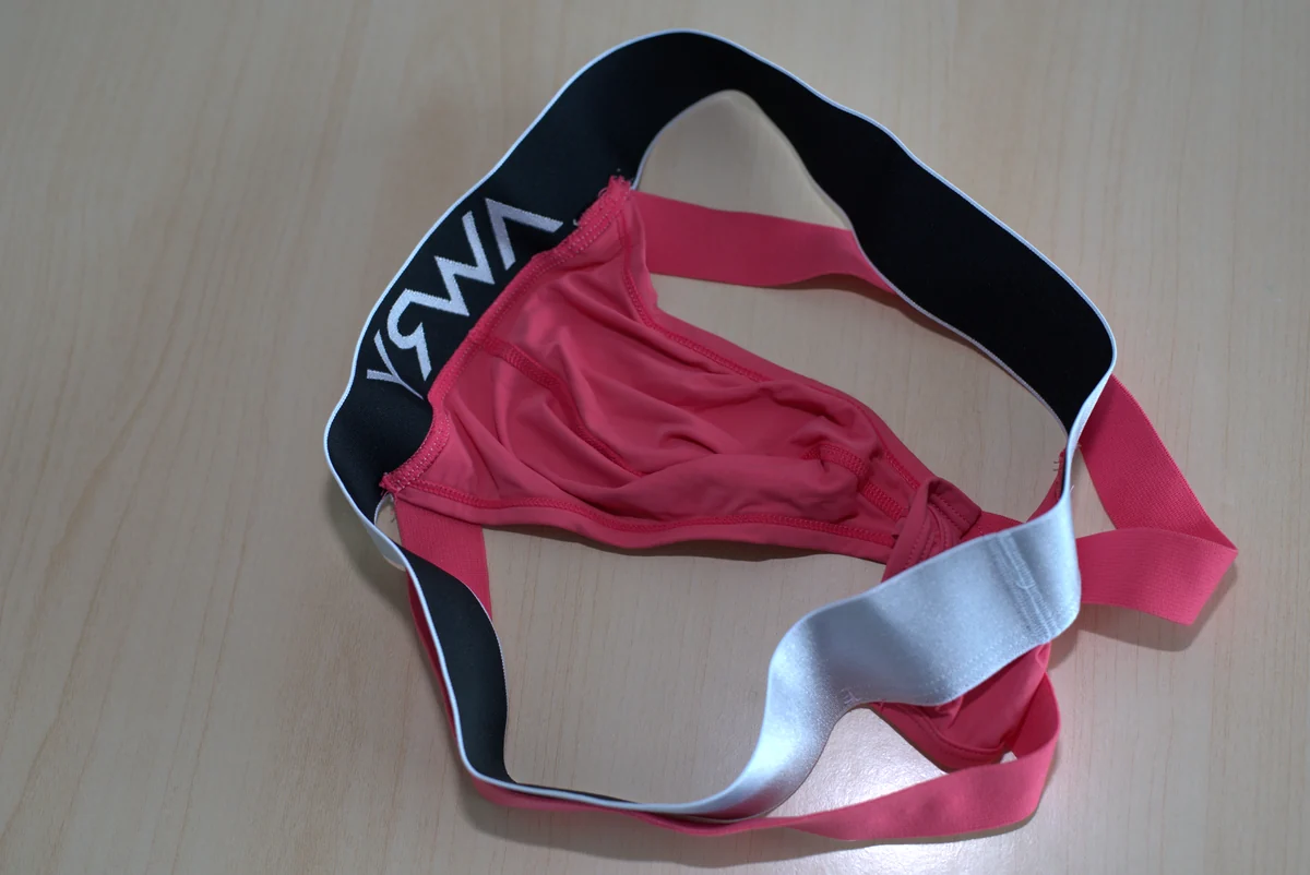 Interior construction of the pink pouch, including its center seam, edge stitching, and elastic attachments.