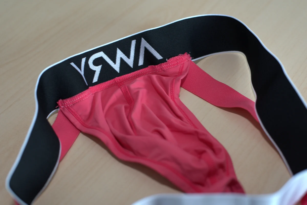 Close view of the pink single-layer fabric, interior stitching, and black reverse of the silver waistband.