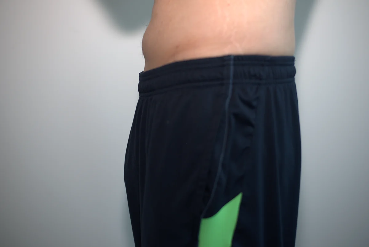 Side view of dark gym shorts worn over the AWRY APEX Jock Thong.