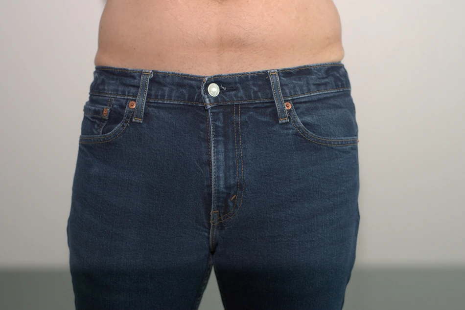 Navy AWRY CHEEKY Thong V2 in Medium: Front under jeans. These clothing photographs are separate from the business-casual work-day wear.