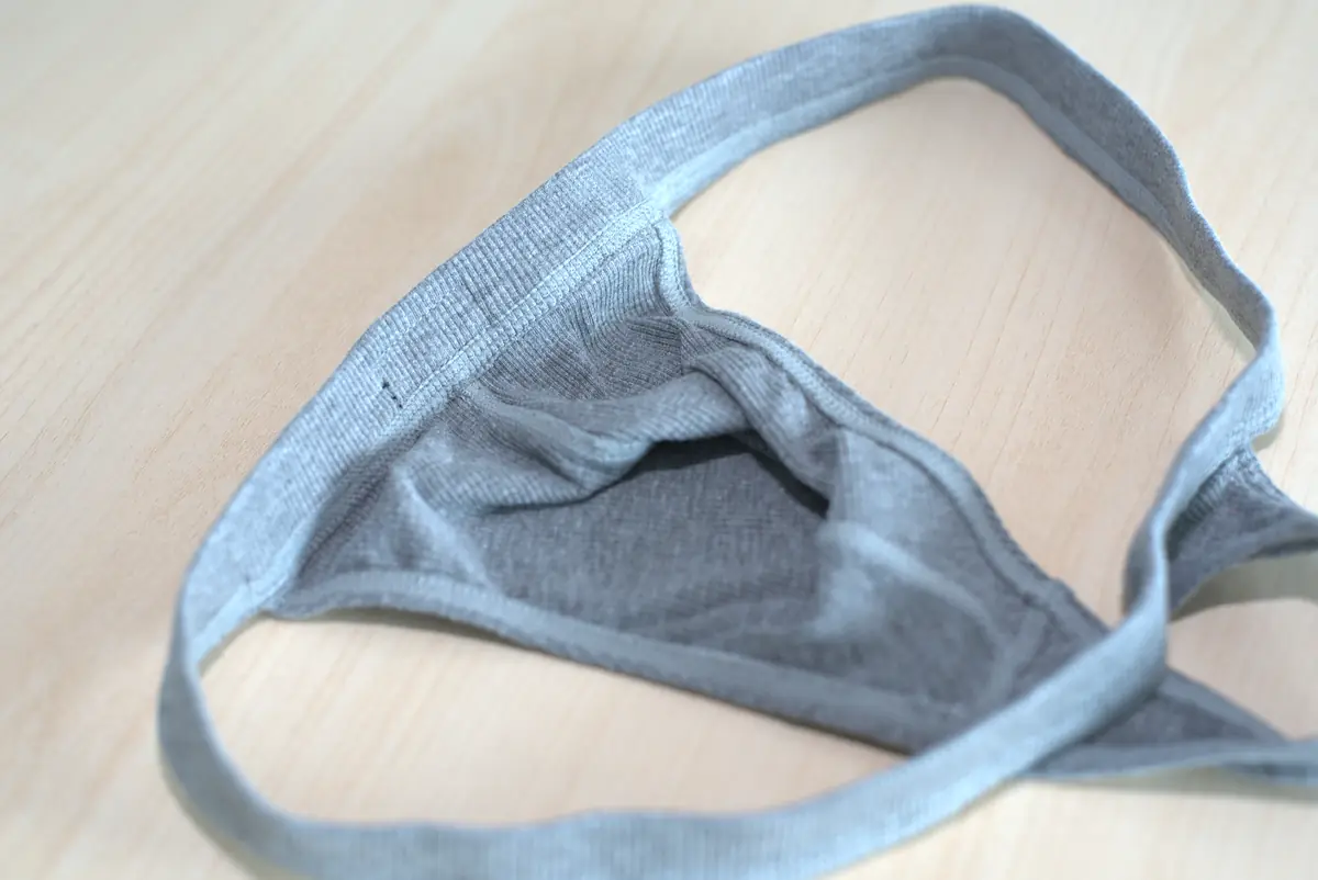 Close interior view of the heather gray ribbed fabric, waistband, stitching, and edge binding.