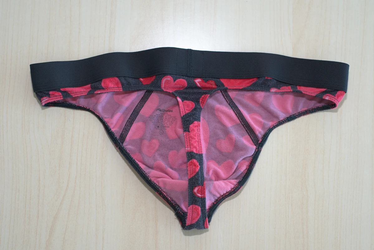 Inside flat lay of the MeUndies Pouch Front Thong, showing the broad front panel, rear strap, waistband and printed label.
