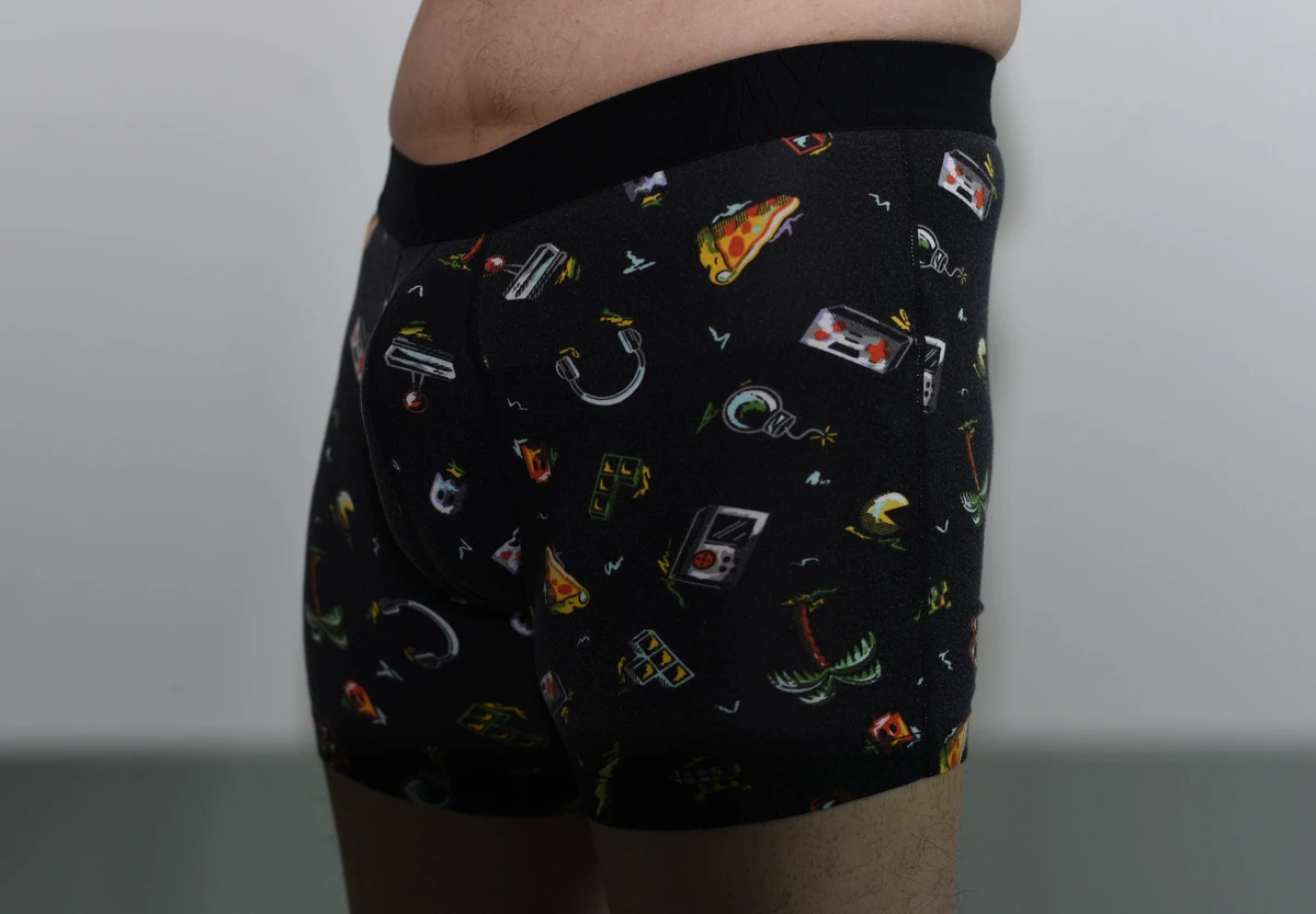 Three-quarter view of the black patterned SAXX boxer brief, with the pouch, hip and leg hems visible.